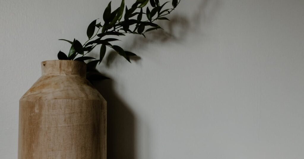 A minimalist kitchen setup featuring a wooden vase with greenery and two white ceramic bowls